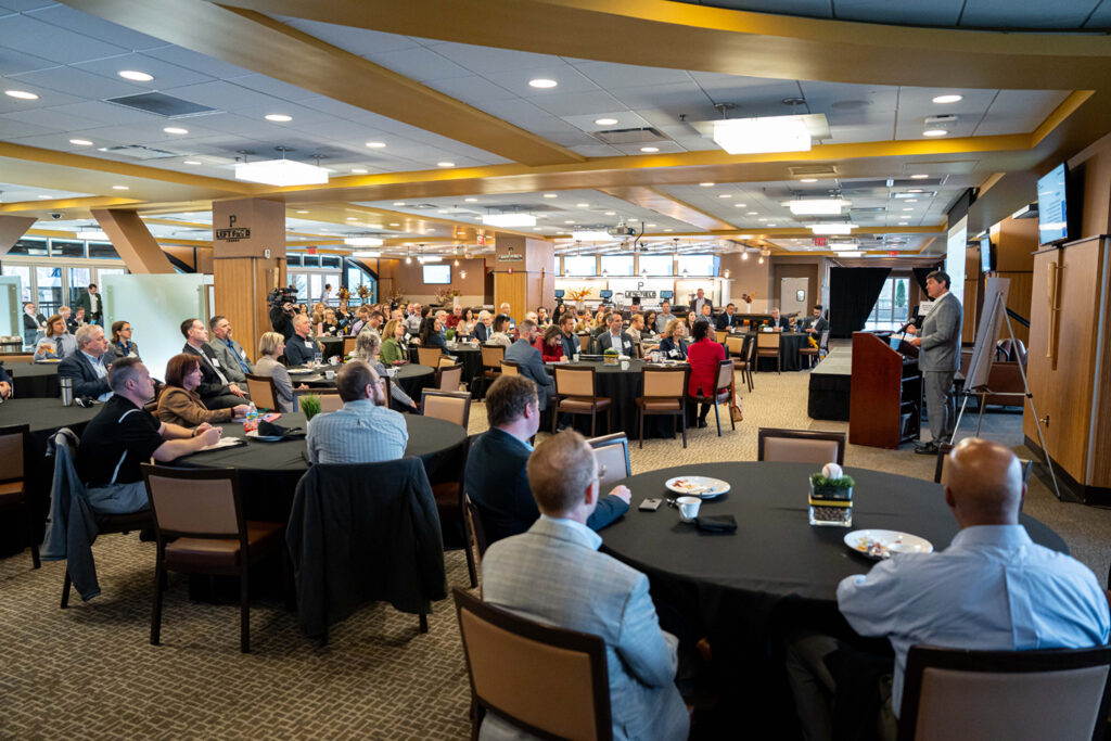 Guests seated at tables in the Left Field Lounge during the 2024 C-Suite Summit, as Bob Nutting, CEO of the Pittsburgh Pirates and CEOs for Sustainability member, speaks at the podium.